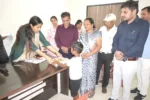 कलेक्टर नेहा मीना जनसुनवाई के दौरान छात्र प्रिंस को निःशुल्क पाठ्यपुस्तकें प्रदान करते हुए।